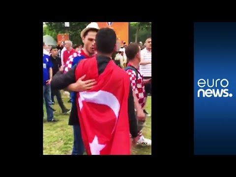 مشجعو كرة القدم للفريقين التركي والكرواتي يتعانقون بعد انتهاء المباراة