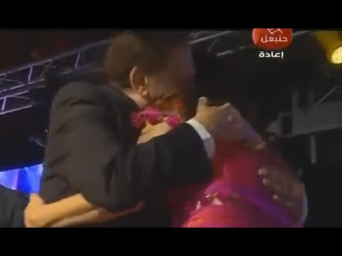 شاهد  عادل إمام ينهال على مذيعة بالقبلات والأحضان