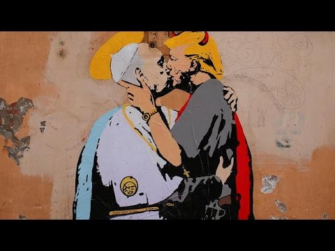شاهد  ملصق قُبلة شيطانية بين الرئيس الأميركي وبابا الفاتيكان