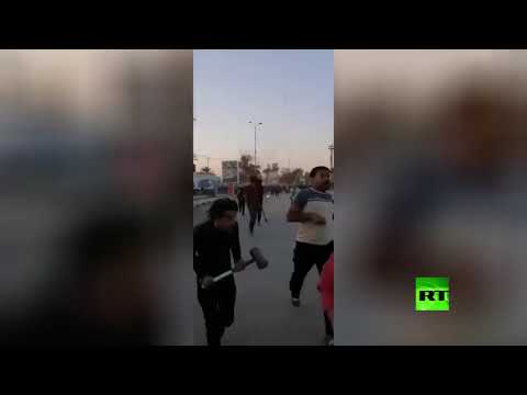 شاهد صدامات في النجف بين محتجين وأصحاب القبعات الزرق