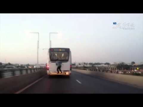 شاهد شاب يخاطر بتسلق حافلة