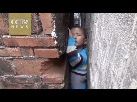 قوات المطافئ تنقذ طفلًا صينيًا علق بين منزلين